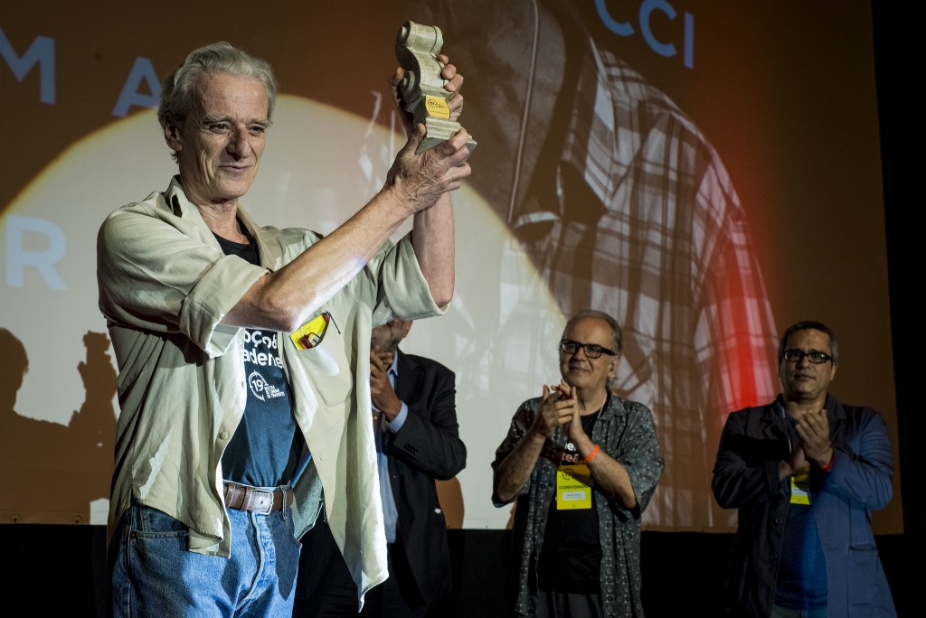 Sob aplausos de pé, Andrea Tonacci ergue o Troféu Barroco em Tiradentes - Foto: Leo Lara/Universo Produção/Divulgação