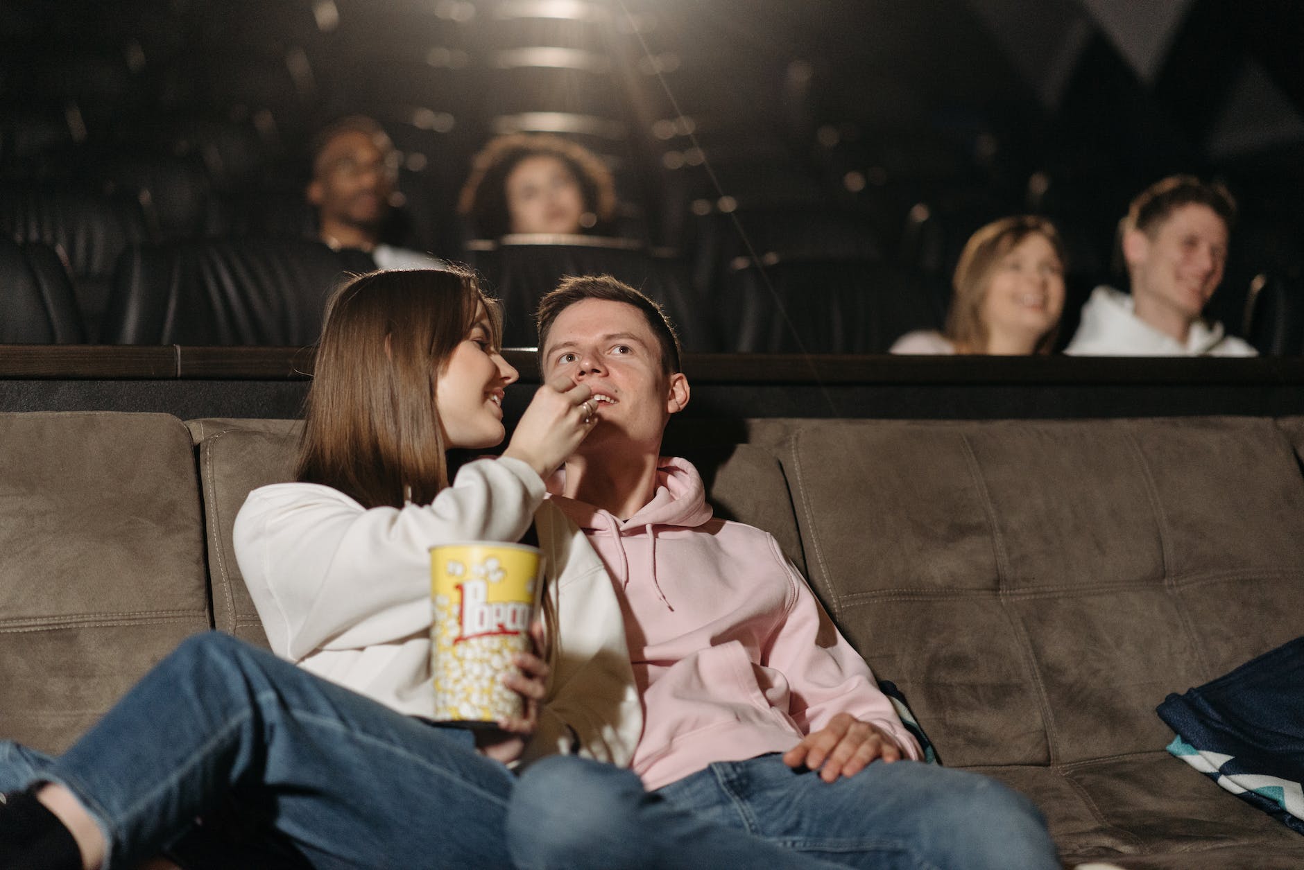 couple watching movie in a cinema theater eating popcorn