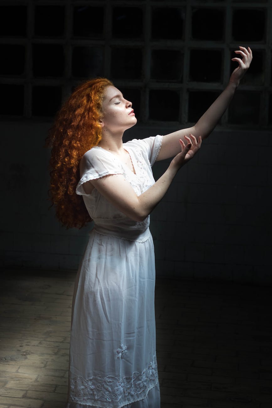 woman wearing white dress raising her hands