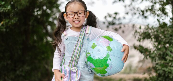 smiling girl holding an inflatable globe
