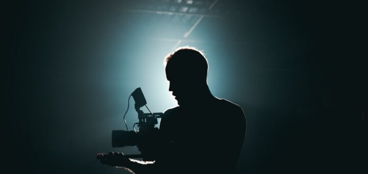 silhouette of man standing in front of microphone