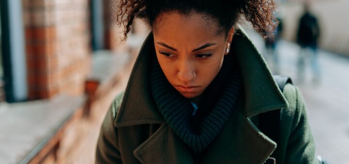 close up photo of a lonely woman in green trench coat